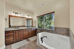 Full bathroom with a tub with jets, double vanity, and light tile patterned floors