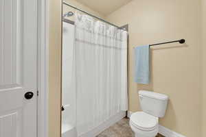 Full bathroom featuring shower / bath combo with shower curtain and tile patterned floors