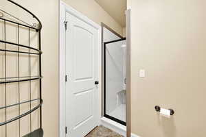 Full bath featuring a shower stall and light tile patterned floors
