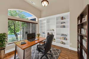 Office area featuring dark wood-style flooring and baseboards