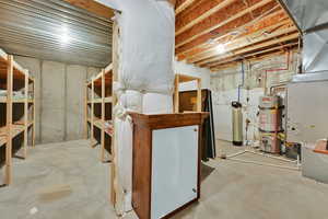 Unfinished below grade area featuring secured water heater and a water softener system