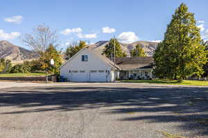 View of front of home with a mountain view, gravel driveway, a garage, and a porch
