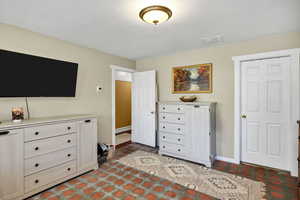 Bedroom featuring baseboards and a textured ceiling