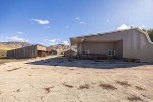Rear view of barn #2, an outdoor structure, a mountain view, and driveway
