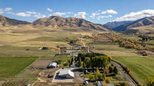 Aerial view of property and surrounding area with rural landscape and a mountainous background
