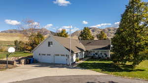 Traditional home featuring a front lawn, a mountain view, a garage, concrete driveway, and covered porch