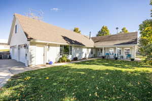 View of front of home featuring a garage, a front porch, a front yard, a shingled roof, and concrete driveway