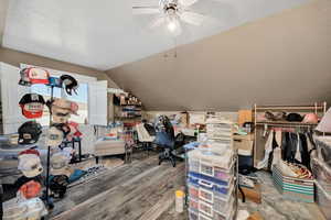 Additional living space on second level with a textured ceiling, wood finished floors, lofted ceiling, an office area, and a ceiling fan