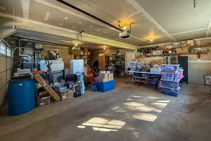 Garage featuring a garage door opener and a workshop area