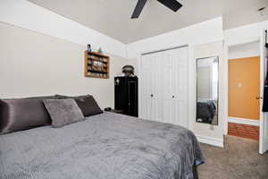 Carpeted bedroom with a closet and a ceiling fan