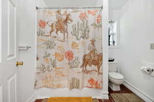 Full bath with baseboards and toilet