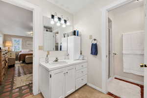 Bathroom with vanity, a stall shower, ensuite bath, and light colored carpet