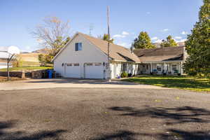 View of front of property with driveway, a front yard, and a garage