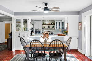 Dining room with concrete tile flooring and a ceiling fan