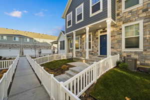Entrance to property with covered porch and stone siding