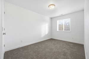 Unfurnished room featuring carpet floors and baseboards