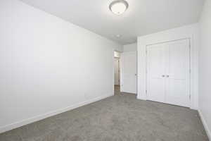 Unfurnished bedroom with carpet and a closet