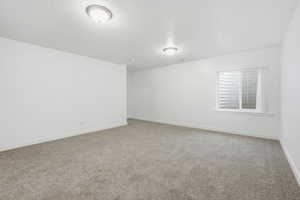 Spare room featuring light carpet and a textured ceiling