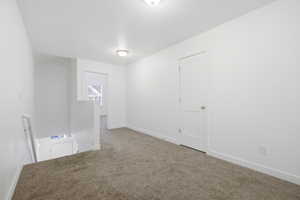 Empty room with carpet floors and baseboards