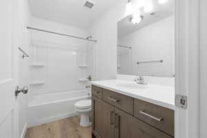 Bathroom with shower / tub combination, vanity, and light wood finished floors