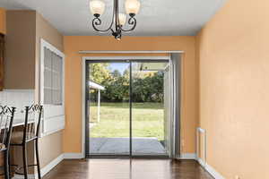 Doorway to outside with a chandelier and wood finished floors