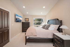 Bedroom with recessed lighting, light colored carpet, and vaulted ceiling