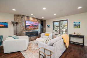 Living room featuring recessed lighting, a fireplace, and dark wood finished floors