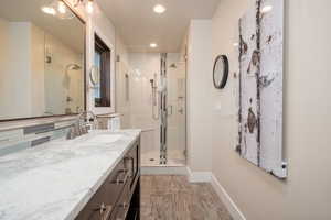 Bathroom with vanity, a stall shower, light wood-type flooring, and recessed lighting