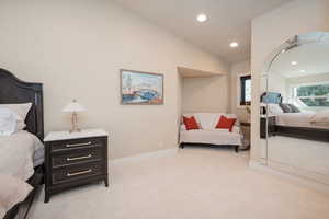 Bedroom with vaulted ceiling, light carpet, and recessed lighting