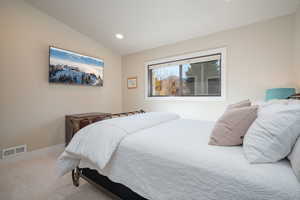 Carpeted bedroom featuring recessed lighting and lofted ceiling