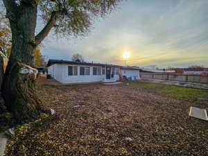 Back of property at dusk with stucco siding and a patio area
