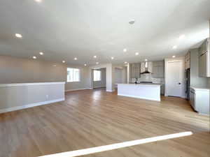 Unfurnished living room with light wood-style flooring, recessed lighting, and a textured ceiling