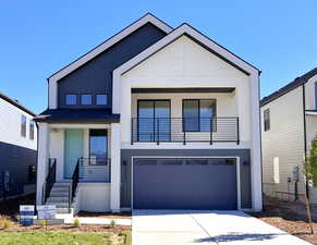 Contemporary house with concrete driveway, covered porch, a garage, board and batten siding, and roof with shingles
