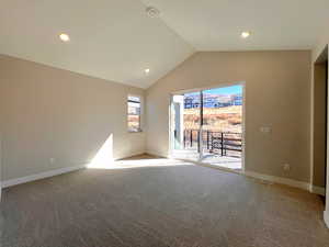 Empty room with vaulted ceiling, light carpet, and recessed lighting