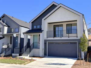 Contemporary home featuring driveway, a garage, stucco siding, and a porch