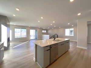 Kitchen with open floor plan, a center island with sink, recessed lighting, a textured ceiling, and dishwasher
