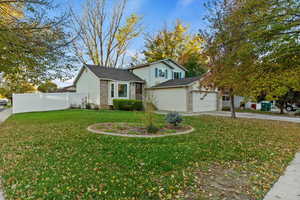 Tri-level home featuring concrete driveway, brick siding, an attached garage, and a shingled roof