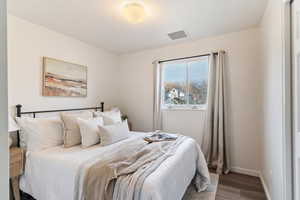 Bedroom featuring wood finished floors and baseboards