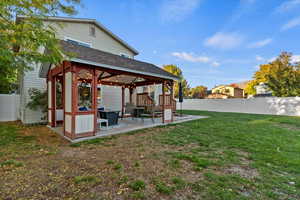 Fenced backyard featuring a gazebo and a patio