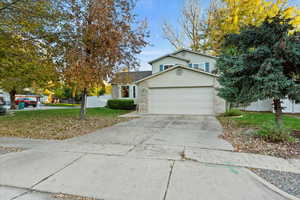 Traditional-style home featuring concrete driveway, brick siding, and a garage