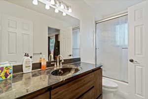 Bathroom with vanity and enclosed tub / shower combo