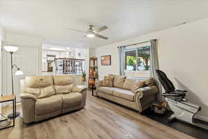 Living room featuring wood finished floors and a ceiling fan