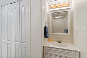 Bathroom featuring vanity and a closet