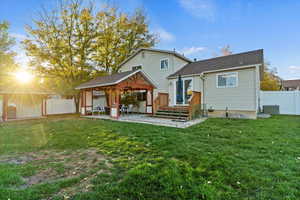 Rear view of house with a fenced backyard, a patio, and roof with shingles