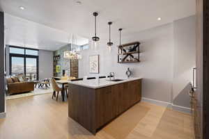 Bar area featuring modern cabinets,  wood floors, decorative light fixtures, quartz counters, and recessed lighting