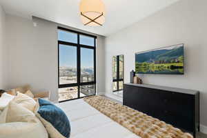 Bedroom featuring floor to ceiling windows and baseboards
