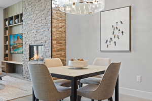 Dining area featuring a stone fireplace and wood finished floors