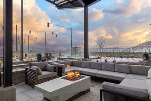 Patio terrace at dusk featuring an outdoor living space with a fire pit, a patio area, and a mountain view