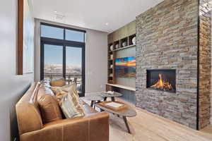 Living area featuring a fireplace, built in features, and wood  floors