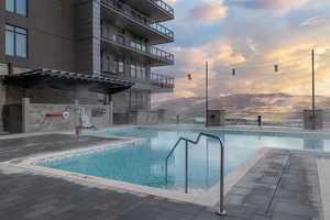 Pool at dusk featuring a community pool and a mountain view